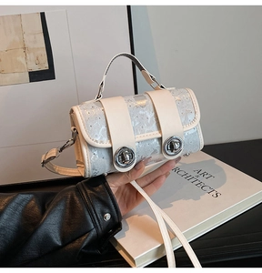 Detail der cremeweißen Mini-Tasche mit Marmortextur und silbernem Metallschloss
