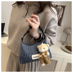 Sac demi-lune en denim bleu avec bandoulière en cuir et un joli porte-clés ours