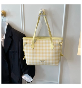 Detail of yellow and white checkered tote bag with drawstring accents and logo printing