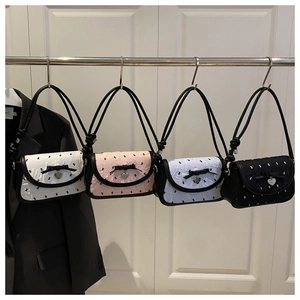 Detail view of colorful pleated crossbody bags with bows and heart shaped pendants