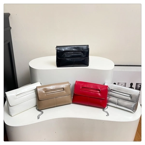 Cinq pochettes enveloppes de différentes couleurs avec bandoulières sur un socle blanc