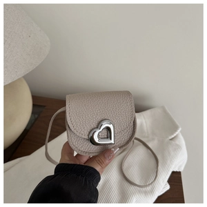 Detail of beige pebbled leather mini bag featuring a silver heart-shaped metal clasp lock