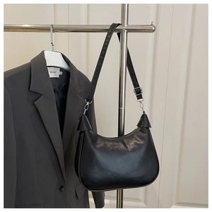 Close-up of black leather hobo bag with adjustable strap and silver metal hardware details