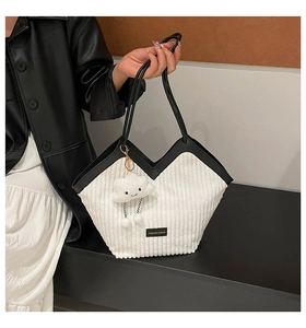 Détail du cabas en velours côtelé blanc avec bordure en cuir noir et breloque nuage