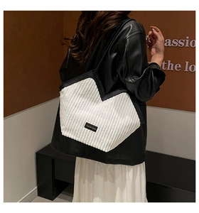 Detail of white corduroy tote bag showing V-shaped opening and reinforced black edges