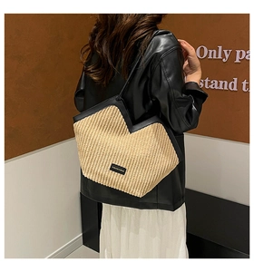 Close-up of beige corduroy tote bag with black leather trim and fashion patch