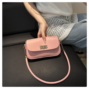 Détail du sac à bandoulière rose avec fermoir rotatif en métal doré à texture tissée
