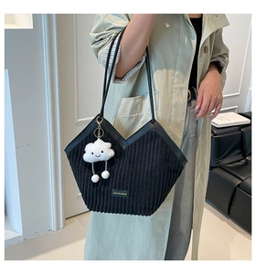 Detail of black corduroy tote bag with V-cut opening and cute white cloud pendant charm