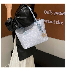 Détail du sac cabas en textile tissé avec bandoulière bleue et pendentif doré M