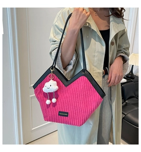 Detail of fuchsia corduroy tote bag with V-shaped trim and white cloud plush charm