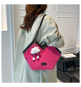 Détail du sac cabas en velours côtelé rose avec garniture en cuir noir et breloque nuage