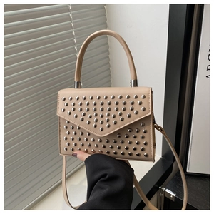 Detail of apricot rivet handbag with silver studs and V-shaped pattern close-up