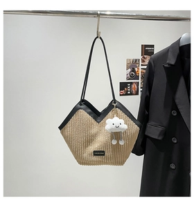 Detail of khaki corduroy tote bag with V-shaped black leather trim and white cloud charm