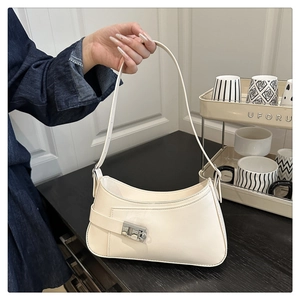 Vue détaillée du sac sous le bras en cuir crème avec boucle argentée et lanière