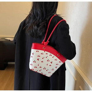 Detail of Korean style red cherry print shoulder bag with knotted strap and retro design