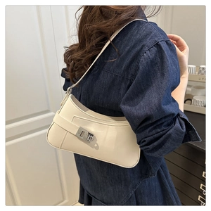 Vue latérale du sac à bandoulière demi-lune blanc crème avec boucle argentée sur modèle