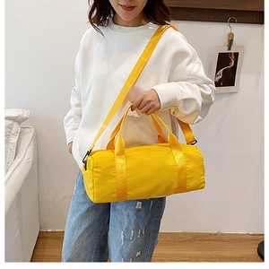 Model wearing a bright yellow cylindrical nylon crossbody bag for fitness and travel
