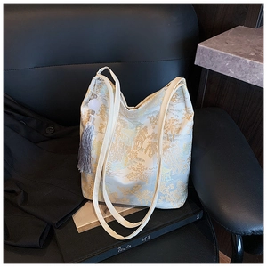 Détail du sac cabas jacquard de style chinois avec motifs dorés et pompon décoratif