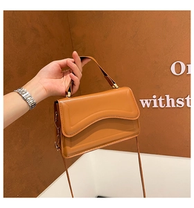 Detailed wave stitching on caramel leather shoulder bag with gold chain strap