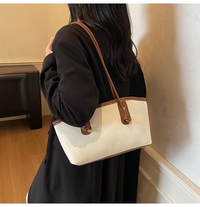 Detail view of large cream tote bag with brown straps and FASHION & BAGS print