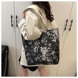 Detail of large tote bag with bamboo print worn over the shoulder by a model