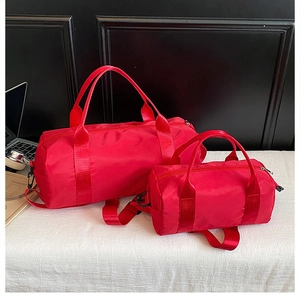 Detail of red cylindrical gym bags in large and small sizes with reinforced handles