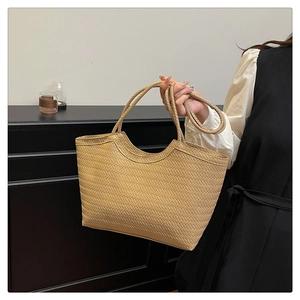 Dettaglio della borsa tote intrecciata kaki con trama fine e manici lunghi