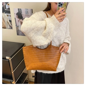 Dettaglio ravvicinato della trama intrecciata marrone e del motivo vintage di una borsa tote