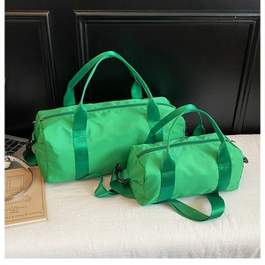 Detail view of large and small green cylindrical sports bags with high-density straps