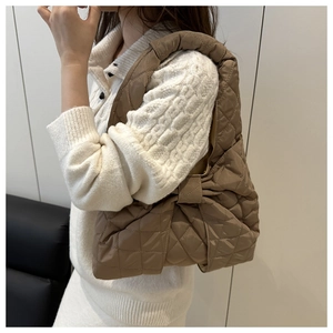 Detail view of coffee brown quilted nylon shoulder bag with elegant bow accent