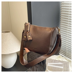 Detail van vintage bruine PU-leren crossbodytas met brede jacquard band en fashion logo