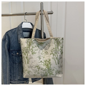 Detail view of large canvas tote bag featuring green bamboo prints and thick woven straps