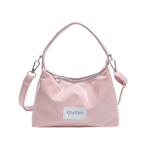 Pink patent leather handbag with a top handle and removable silver-tone strap