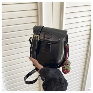 Borsa a sella in pelle nera con tracolla regolabile e ciondolo a fragola rossa
