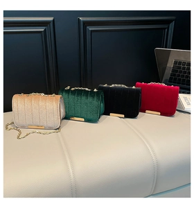 Detail of velvet chain crossbody bags in champagne, green, black and wine red colors