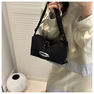 Détail du sac bandoulière en nylon noir avec logo FANYISSA et sangle réglable