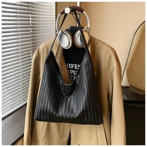 Detail of the high-quality V-shaped woven texture on this black leather tote bag