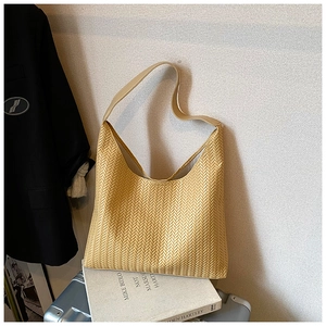 Close-up of beige woven tote bag texture with leather strap against textured background