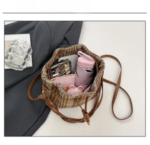 Vista interna che mostra la capienza della borsa a secchiello a quadri con oggetti comuni