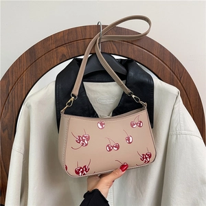 Elegante beige Schultertasche mit Kirschmuster und schmalem Lederriemen in sanftem Licht
