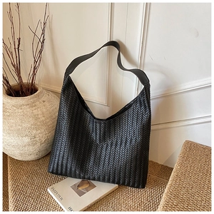 Close-up of black woven hobo shoulder bag with intricate chevron knit pattern detail