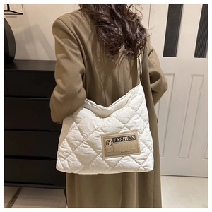 Close-up of quilted white tote bag with diamond stitching and fashion label detail