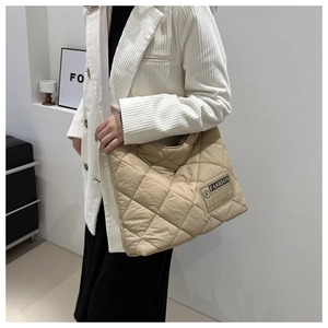 Detail of beige quilted tote bag with diamond pattern and large capacity for daily use