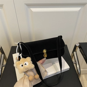 Chic black suede baguette shoulder bag with gold metal clasp and star plush pendant