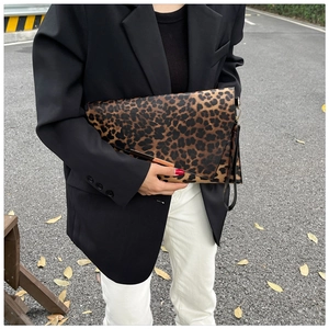 Dettaglio pochette a busta leopardata con finiture in metallo e cinturino da polso fashion