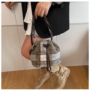 Detalle de la textura de cuadros afelpados y cordón de cuero en este bolso de cubo chic