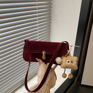 Dark red suede baguette underarm bag with gold twist lock and a cute bear charm