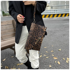 Dettaglio borsa a mano leopardata con inserto in metallo dorato e cinturino