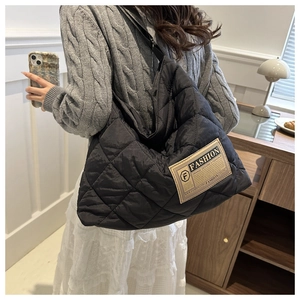 Close-up of black quilted shoulder bag featuring a vintage yellow brand label detail
