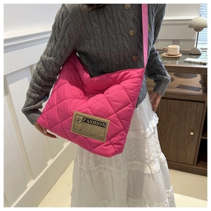 Close-up of bright pink quilted puffer tote bag featuring a vintage style fashion patch